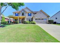 Charming two-story home with stone accents, a well-manicured lawn, and an attached two-car garage at 3975 Silverthorn Trce, Cumming, GA 30028