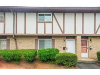 Traditional townhome featuring a brick facade and well-maintained landscaping with trimmed hedges at 2952 N Dekalb Dr # C, Atlanta, GA 30340