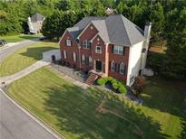 Two-story brick home with landscaped front yard, dark shutters, and a manicured lawn at 3898 Heritage Oaks Dr, Powder Springs, GA 30127