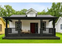 Charming home with a cozy front porch, black trim, and a freshly manicured lawn at 1192 Arlington Sw Ave, Atlanta, GA 30310