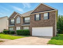 Beautiful two-story brick home with a well-manicured lawn and a two-car garage at 3731 Laramie Rd, Ellenwood, GA 30294