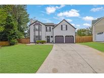 Charming two-story home featuring a manicured front yard and a two-car garage at 1701 English Ivey Nw Ln, Kennesaw, GA 30144