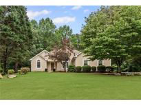 Stunning single-story home with a lush green lawn and mature trees at 775 Tribble Cove Dr, Lawrenceville, GA 30045