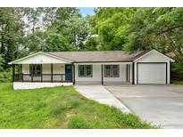 Charming home with a covered porch, manicured lawn, and attached garage at 2326 Brackett Sw St, Marietta, GA 30060
