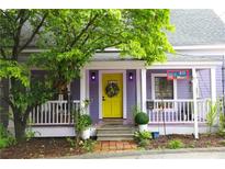 Charming home featuring a bright yellow door, lilac exterior paint, and a welcoming front porch with a seating area at 611 Pickett Se St, Atlanta, GA 30316
