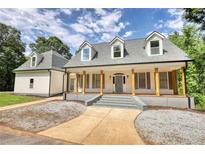 Charming home featuring a spacious front porch with columns and a well-maintained yard at 80 Surrey Chase Drive, Social Circle, GA 30025