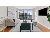 Bright living room features city views, modern decor, and a large window for natural light at 1280 W Peachtree Nw St # 3208, Atlanta, GA 30309