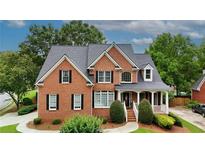 Charming two-story brick home with a well-maintained lawn and mature trees at 793 Fairington Pl, Lawrenceville, GA 30044