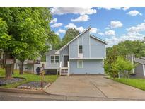 Charming light blue two-story home with a unique roofline, front porch, and well-maintained lawn at 1139 Mainstreet Valley Dr, Stone Mountain, GA 30088