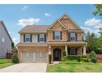 Charming two-story brick home with a well-manicured lawn and a two-car garage at 4090 Danbury Farms Dr, Cumming, GA 30040