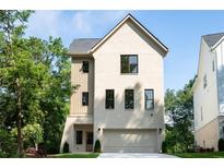 Charming home with brick exterior, black framed windows, and a two-car garage, set amongst lush landscaping at 2745 S Bamby Ne Ln, Brookhaven, GA 30319