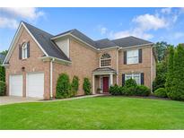 Charming brick two-story home with well-manicured lawn, attached two-car garage, and beautiful architectural details at 3032 Montclair Se Cir, Smyrna, GA 30080