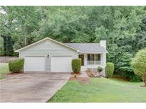 Charming single-story home with a two-car garage, front porch, and mature landscaping at 3960 Rocmar Dr, Snellville, GA 30039