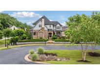Stunning home with mature landscaping, stone accents, and lush green lawn at 4224 Dogwood Bend Park, Berkeley Lake, GA 30096