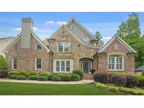 Beautiful brick and stone home featuring manicured landscaping and a charming front entrance at 702 Crescent Cir, Canton, GA 30115