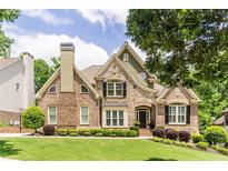 Beautiful brick and stone home with manicured landscaping and a charming architectural design at 702 Crescent Cir, Canton, GA 30115