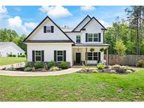 Charming two-story home featuring black shutters and a cozy front porch with stylish outdoor seating at 1417 Woodrow Kay Rd, Rockmart, GA 30153