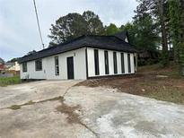 Side view of a remodeled home showing the black trim windows and fresh exterior paint at 6774 Collier Rd, Riverdale, GA 30296