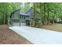Charming two-story home featuring a two-car garage, and a long driveway, surrounded by mature trees at 3966 N Indian Nw Cir, Kennesaw, GA 30144