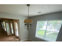 Dining room with chandelier, wood floors, and a window offering natural light at 6684 Crane Ave, Fairburn, GA 30213