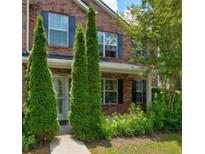Charming brick home featuring mature trees and a well-manicured lawn and a sidewalk at 6684 Crane Ave, Fairburn, GA 30213