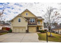 Charming two-story home boasts a stone and siding facade, two-car garage, and well-manicured lawn at 963 Ensign Peak Ct, Lawrenceville, GA 30044