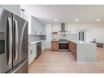 Modern kitchen with stainless steel appliances, white cabinets, and light wood flooring at 2621 Gordon Se Cir, Smyrna, GA 30080