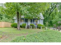 Charming blue home with a white picket fence and lush green landscaping at 859 Sangria Ct, Lawrenceville, GA 30043