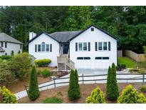 Charming home featuring a two-car garage, front yard landscaping and a welcoming entrance at 2111 Yorkshire Ct, Woodstock, GA 30189