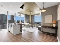 Bright, open living space with floor-to-ceiling windows, modern kitchen, and stylish decor offers stunning city views at 855 Peachtree Ne St # 1703, Atlanta, GA 30308