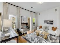 Bright living room boasts natural light from the balcony with a modern sofa and stylish black and white rug at 870 Inman Village Ne Pkwy # 305, Atlanta, GA 30307