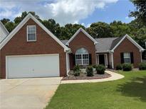 Charming brick home with attached two-car garage, walkway, and beautiful landscaping at 3690 Crescent Walk Ln, Suwanee, GA 30024