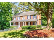 Charming two-story brick home with blue shutters and a welcoming front porch at 4259 Kings Troop Rd, Stone Mountain, GA 30083