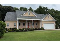 Charming single-story home with a brick facade, manicured lawn, and a covered entrance with elegant white columns at 430 English Ivy Way, Woodstock, GA 30188