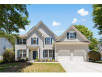Charming two-story home with a two-car garage, a well-manicured lawn, and lovely landscaping at 795 Creek Glen Rd, Mableton, GA 30126