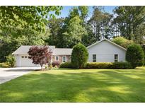 Charming single-story home featuring a well-maintained lawn, attached garage, and mature landscaping at 3519 Oak Knoll Dr, Marietta, GA 30068