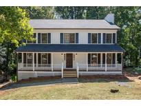 Charming two-story home featuring a welcoming front porch, well-maintained lawn, and classic design at 4166 Riverhill Ne Ct, Roswell, GA 30075