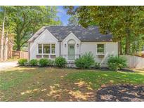 Charming painted brick home with landscaped front yard and mature trees at 2048 Mcafee Rd, Decatur, GA 30032
