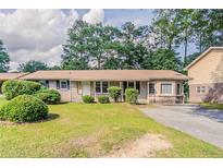 Charming single-story home with a well-maintained lawn, mature landscaping, and inviting curb appeal at 3420 Leisure Ln, Atlanta, GA 30349