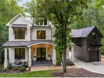 Beautiful stone house with a metal roof, a front porch with swing, and attached garage at 306 Pinecrest Ne Rd, Atlanta, GA 30342