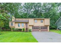 Charming two-story home with a well-maintained lawn, mature trees, and a two-car garage at 3440 Quinn Ridge Dr, Snellville, GA 30039