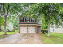 Charming two-story brick home with a two-car garage and a well-maintained front yard at 3469 Stoneleigh Walk, Lithonia, GA 30038