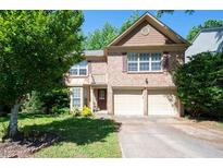 Traditional two-story brick home featuring an attached two-car garage and a well maintained lawn at 4003 Maple Ridge Nw Ln, Acworth, GA 30101