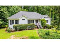 Charming ranch-style home with a well-manicured lawn, lush landscaping, and inviting front porch at 567 Leah Drive, Powder Springs, GA 30127