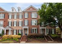Charming brick townhome with neat landscaping, black shutters, and a welcoming front entrance at 4503 Kendall Way, Roswell, GA 30075