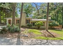 Charming single-story home with a well-maintained lawn and mature trees enhancing its curb appeal at 609 Redwood Drive Dr, Woodstock, GA 30189