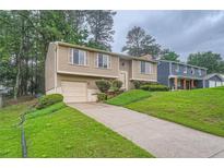 Inviting two-story home boasts a well-manicured front yard and attached one car garage at 4470 Hopkins Lake Nw Dr, Duluth, GA 30096