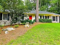 Charming ranch style home with a manicured front yard, brick accents, black shutters, and bright red front door at 773 N Superior Ave, Decatur, GA 30033