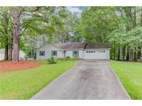 Charming one-story home featuring a well-manicured lawn and an extended driveway leading to an attached two-car garage at 2088 Blackberry Ln, Auburn, GA 30011