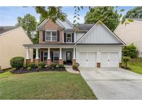 Charming two-story home featuring a welcoming front porch, two-car garage, and a well-manicured lawn at 4266 Suwanee Brook Ct, Buford, GA 30518